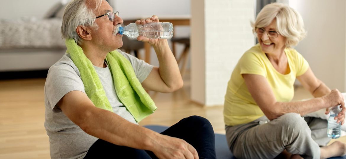 mature-couple-having-water-break-while-exercising-home